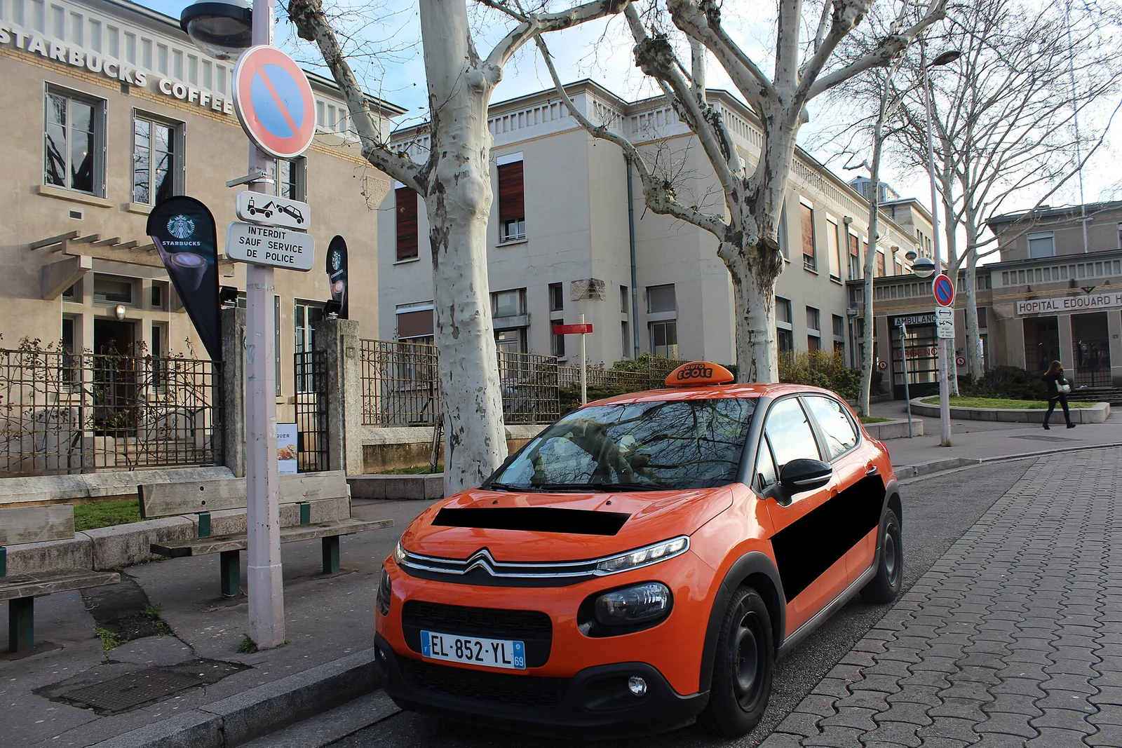 Voiture d’auto-école stationnée dans une rue.